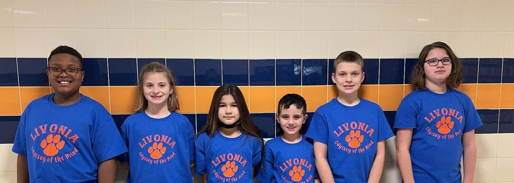 6 students standing in a line wearing matching blue shirts with an orange paw