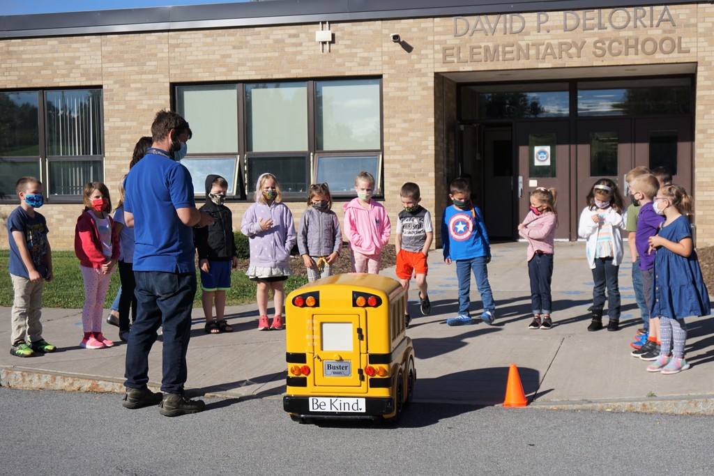 students standing around a remote control bus