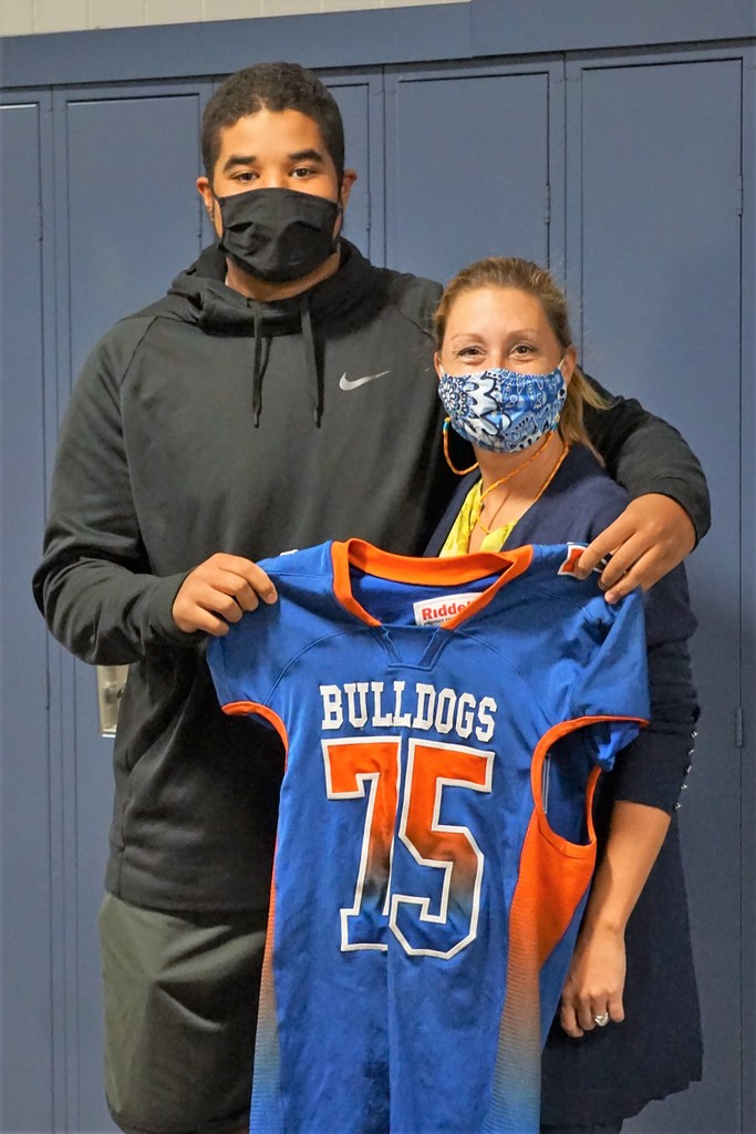 student and faculty member with football jersey