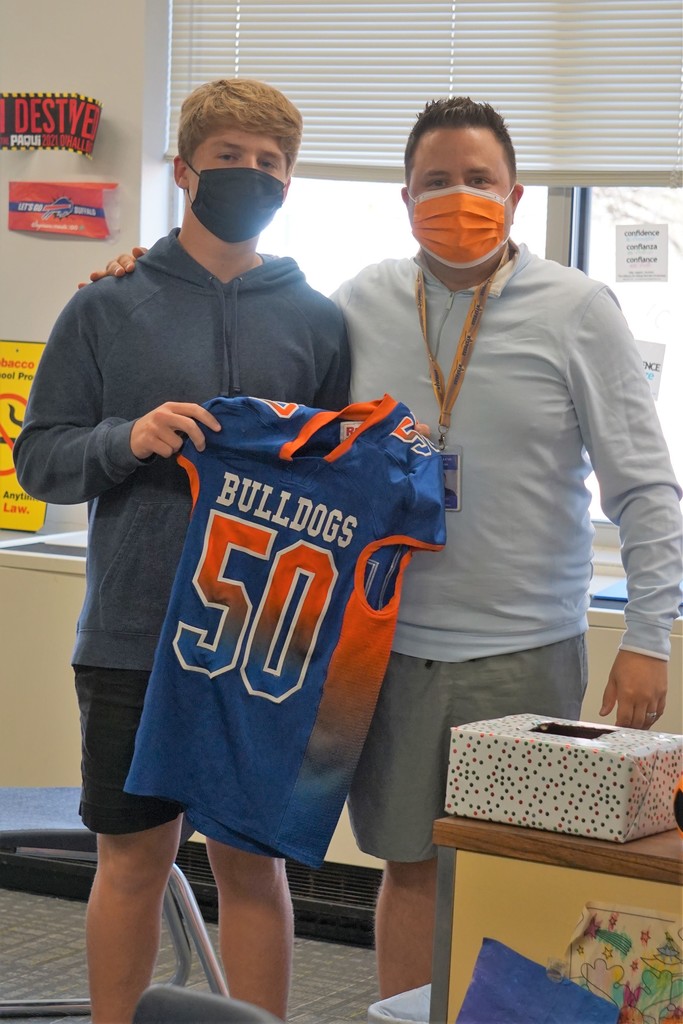 student and faculty member with football jersey