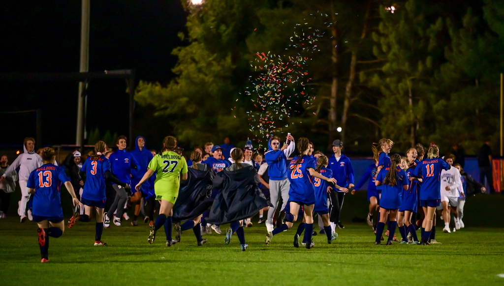 soccer team and fans celebrating with a confetti cannon