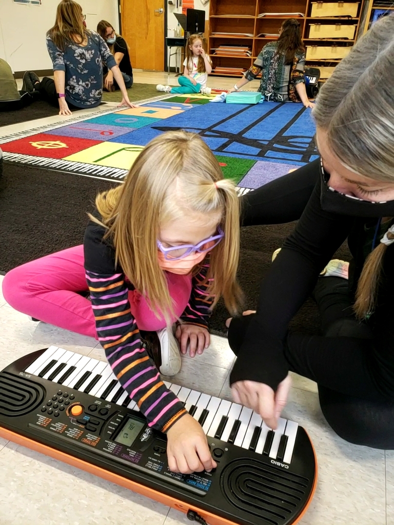 student and staff member with piano