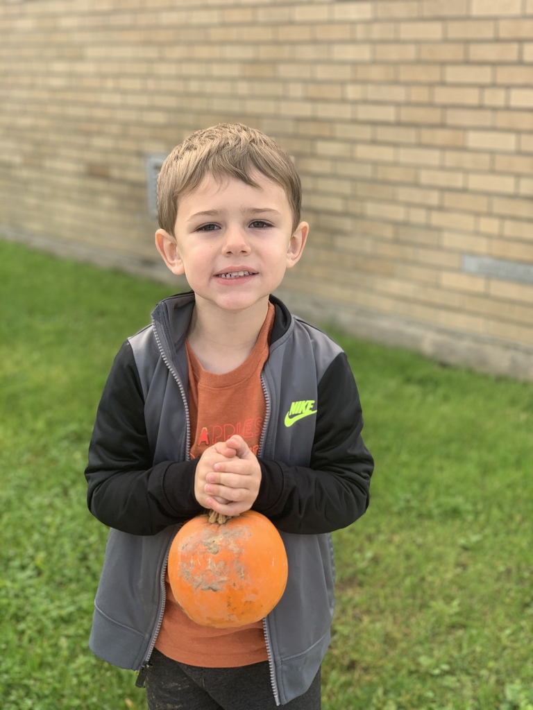 student smiling holding pumpkin