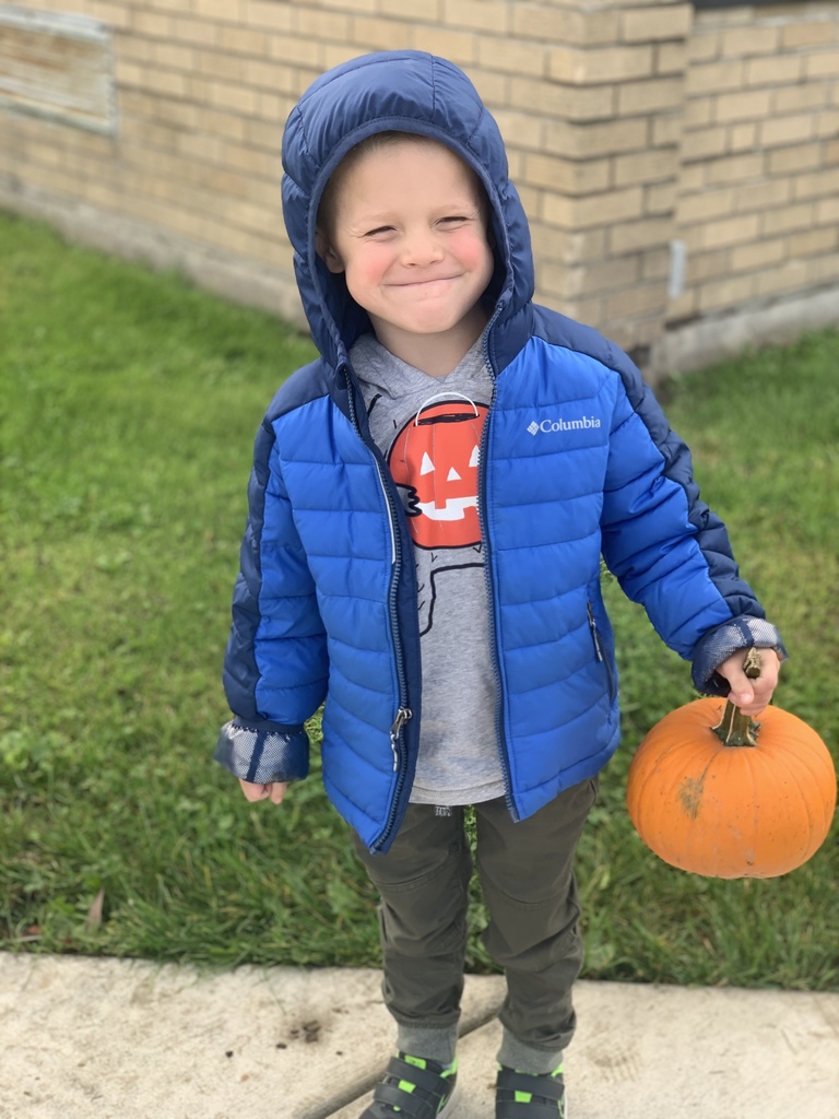 student smiling holding pumpkin