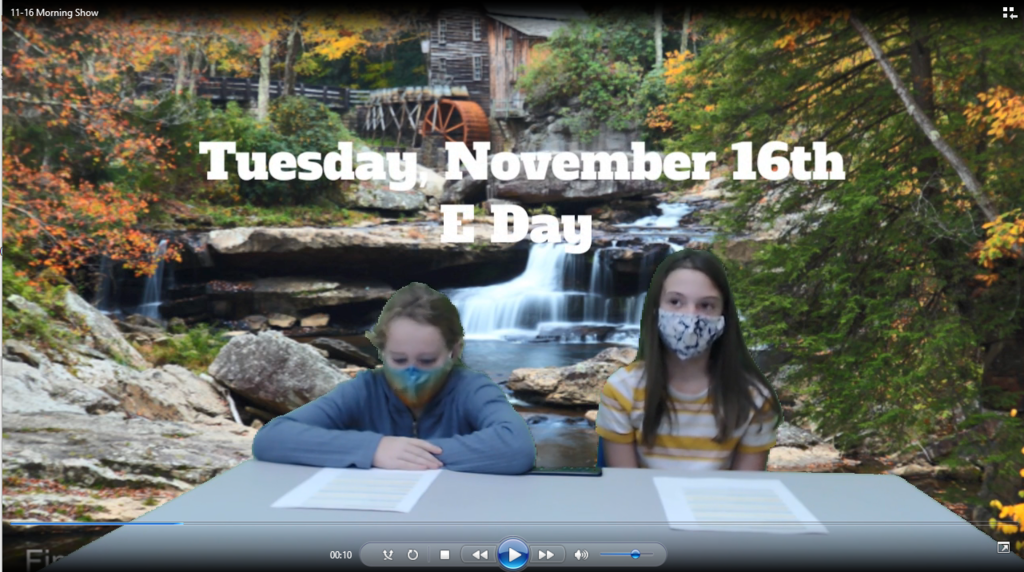 two students at news desk with waterfall on greenscreen