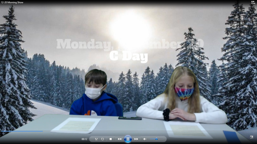 two students at desk with snowy trees on green screen