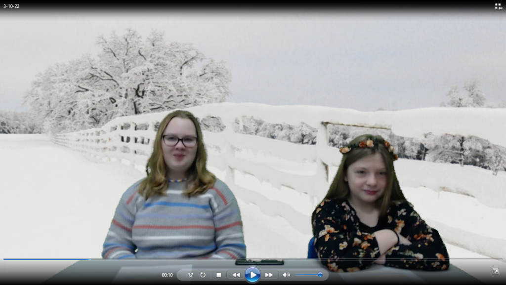 two students at news desk with snowy field and fence on green screen