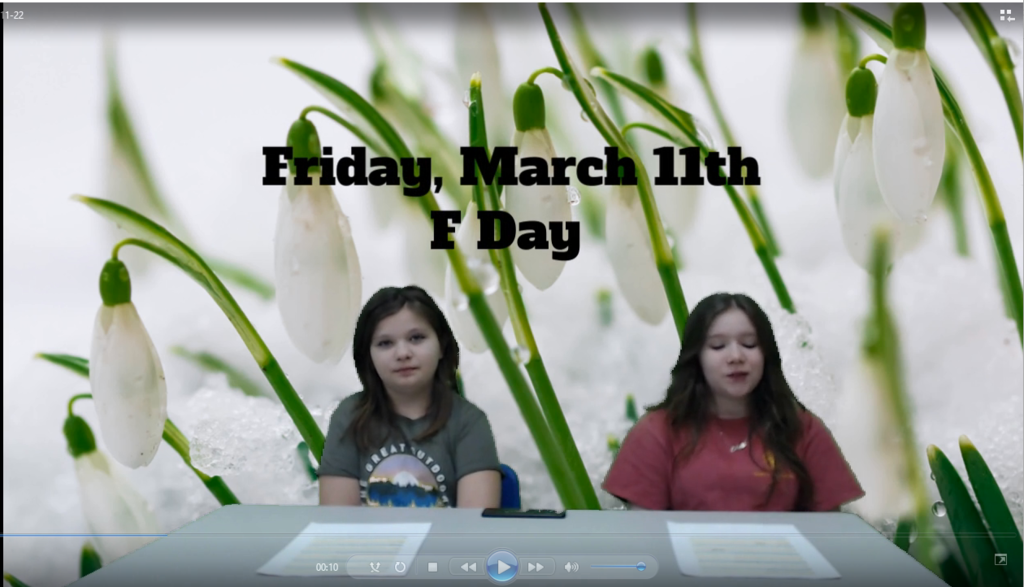 Two students at news desk with white snow drop flowers on green screen
