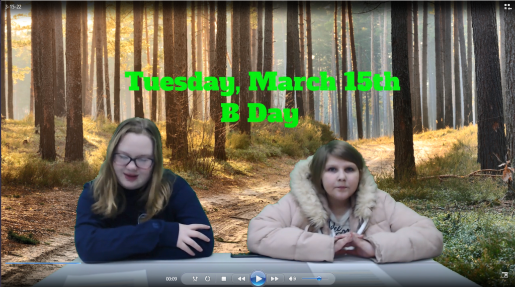 two students at news desk with sunny treed path on green screen