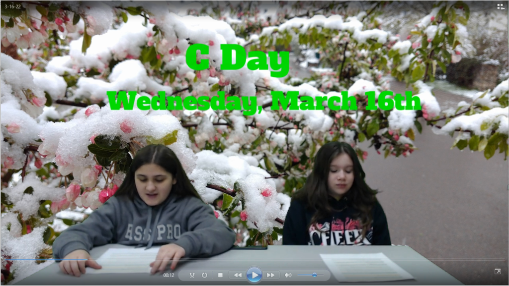 two students at news table with winter snowy spring blossoms on green screen