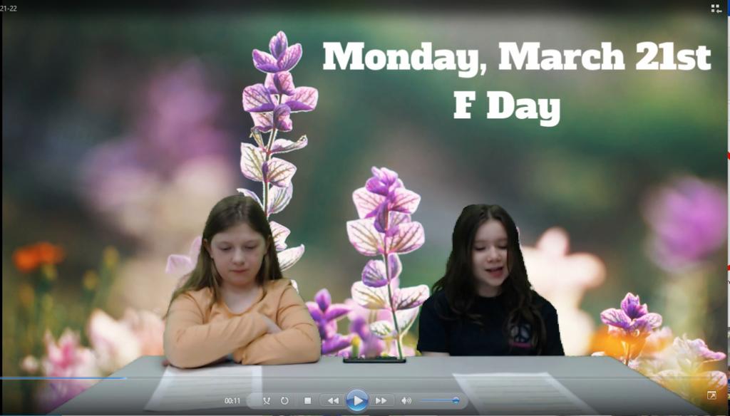 two students at news table with spring flower on green screen