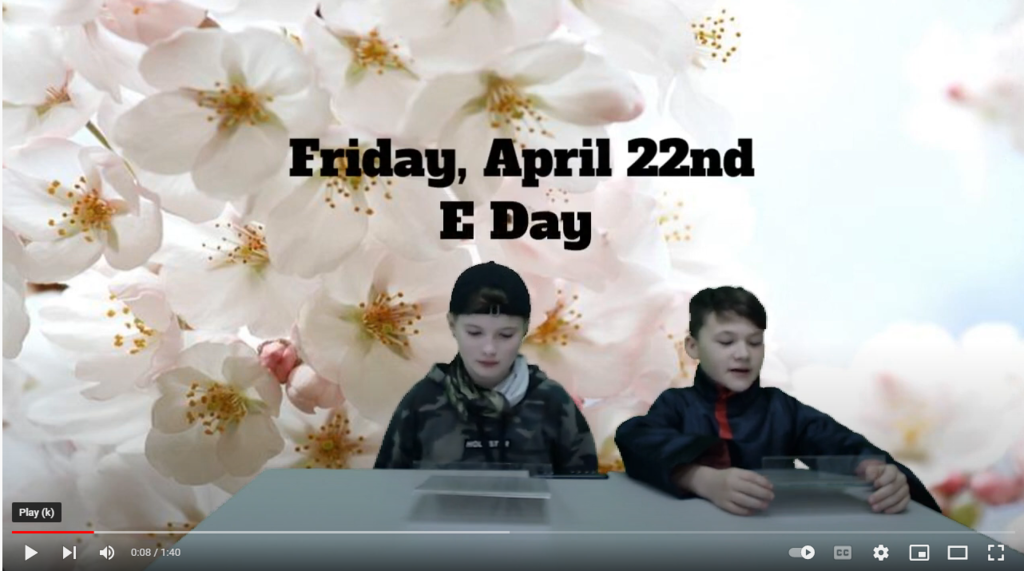 two students at news desk with flower blossoms on green screen