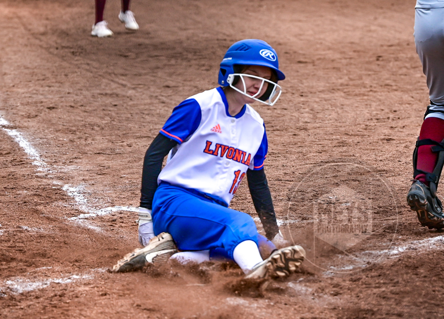softball player sliding into home base