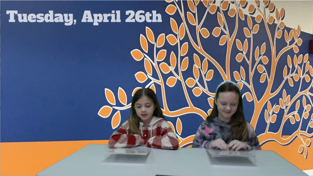 two students at news desk with foyer of the Elementary school on green screen