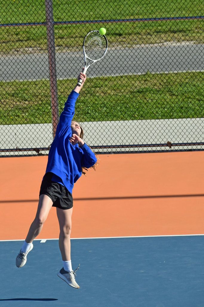 tennis player reaching for ball