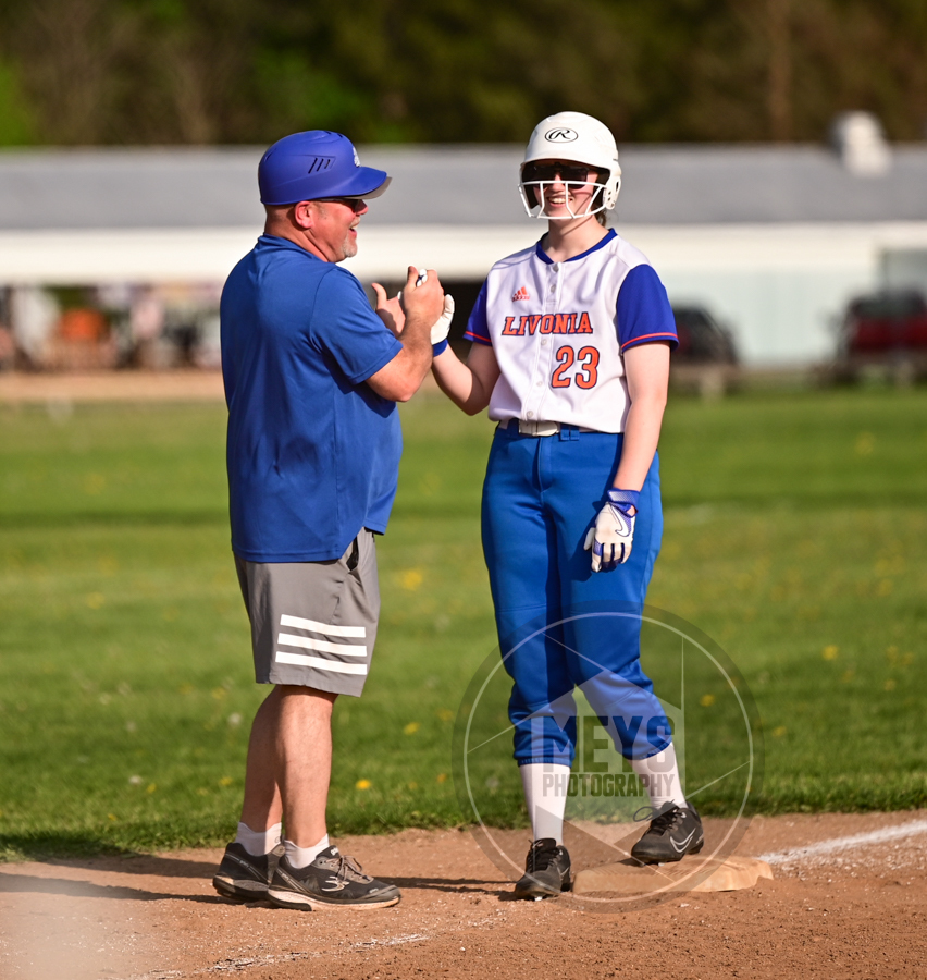 softball player on base with coach