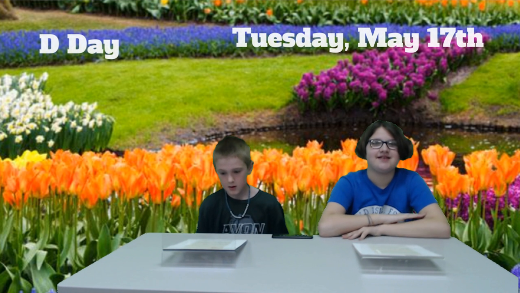 two students at news desk with tulips on green screen
