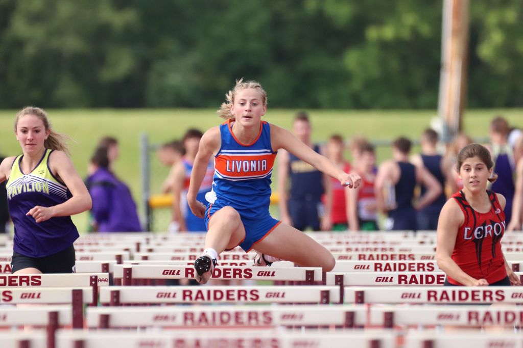 athlete going over hurdles