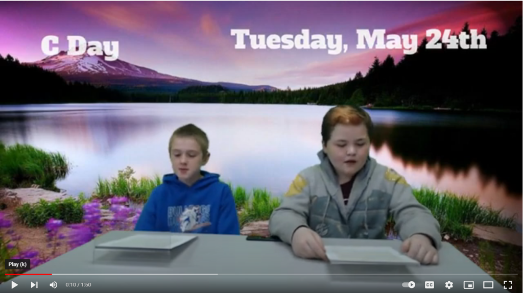 two students at news desk with a mountain lake at dawn on green screen. 