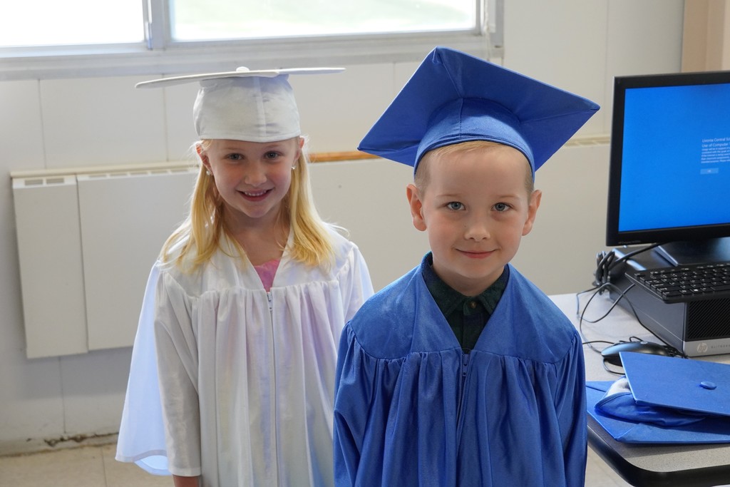two kindergarten students in cap and gown