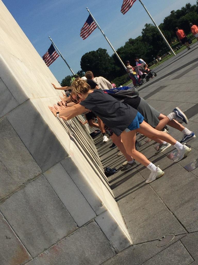 students pretending to push over Washington monument