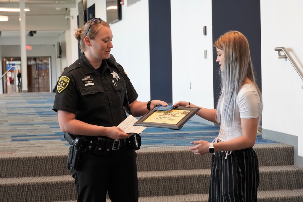 school resource officer giving award to student
