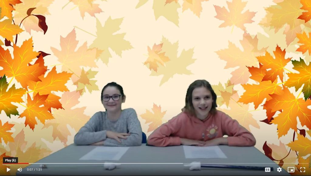 two students at news desk with leaves on green screen
