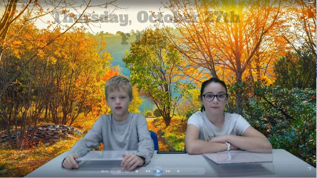 twos students at news deskw ith fall trees on green screen