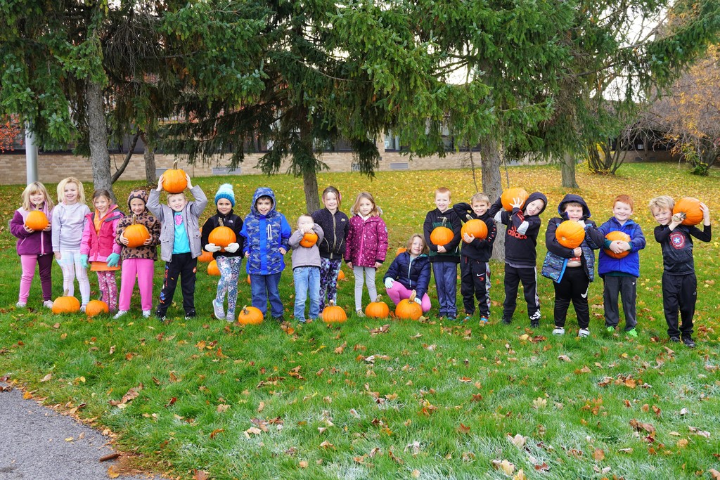 students holding pumpkins