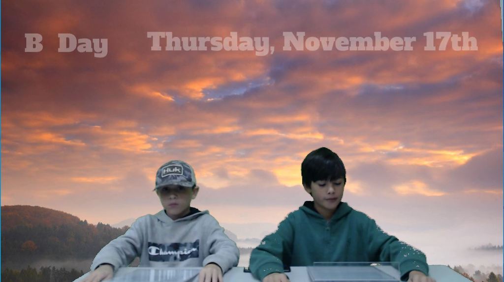 two students at news desk with sunrise on green screen