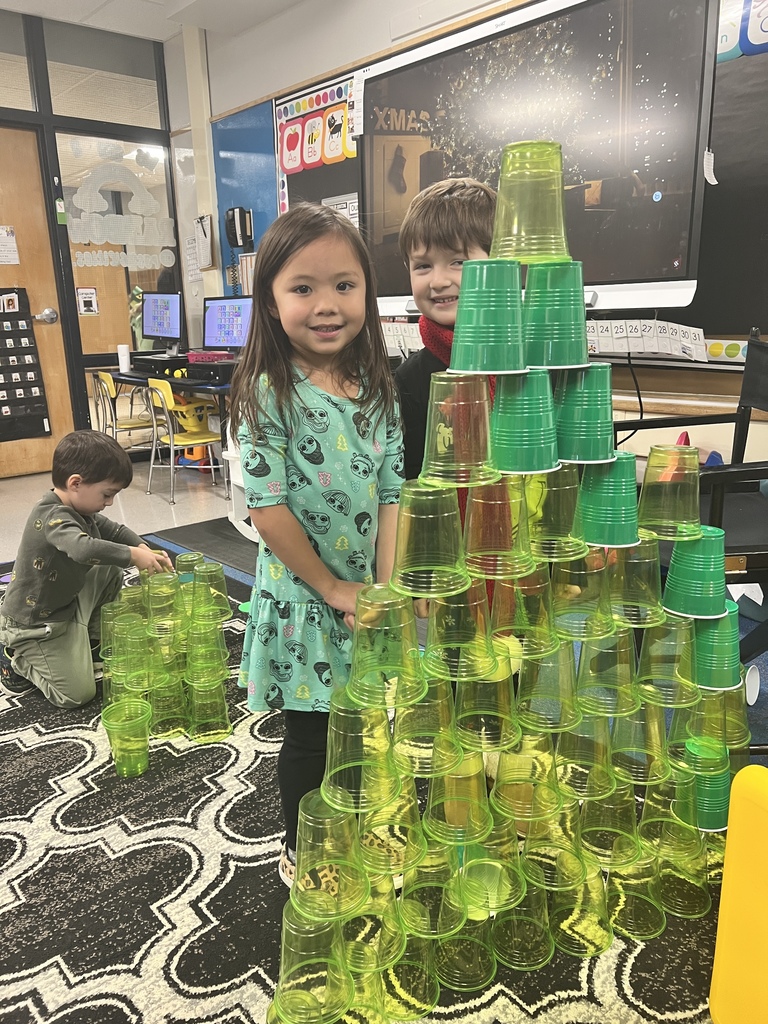 students stacking green cups in a triangle