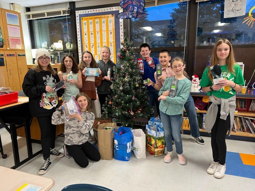 students at christmas tree with personal care items