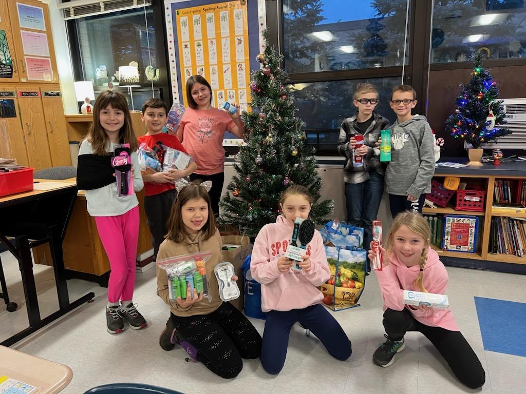 students at christmas tree with personal care items