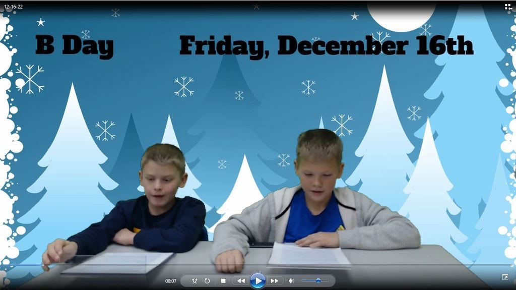 two boys at news desk with graphic of winter trees on green screen