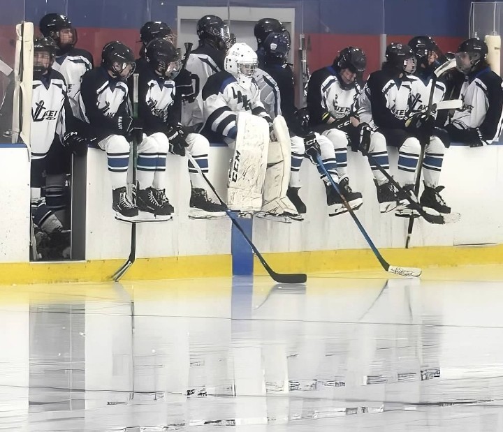 hockey players sitting on wall of rink