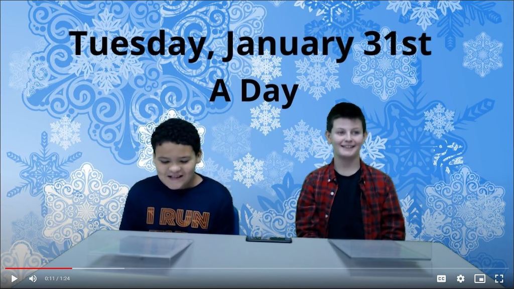 two students at news desk with graphic of snowflakes on green screen