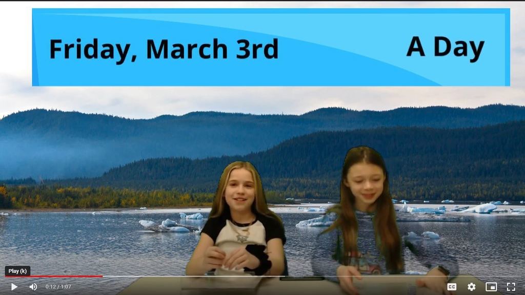 two students at news desk with lake on green screen