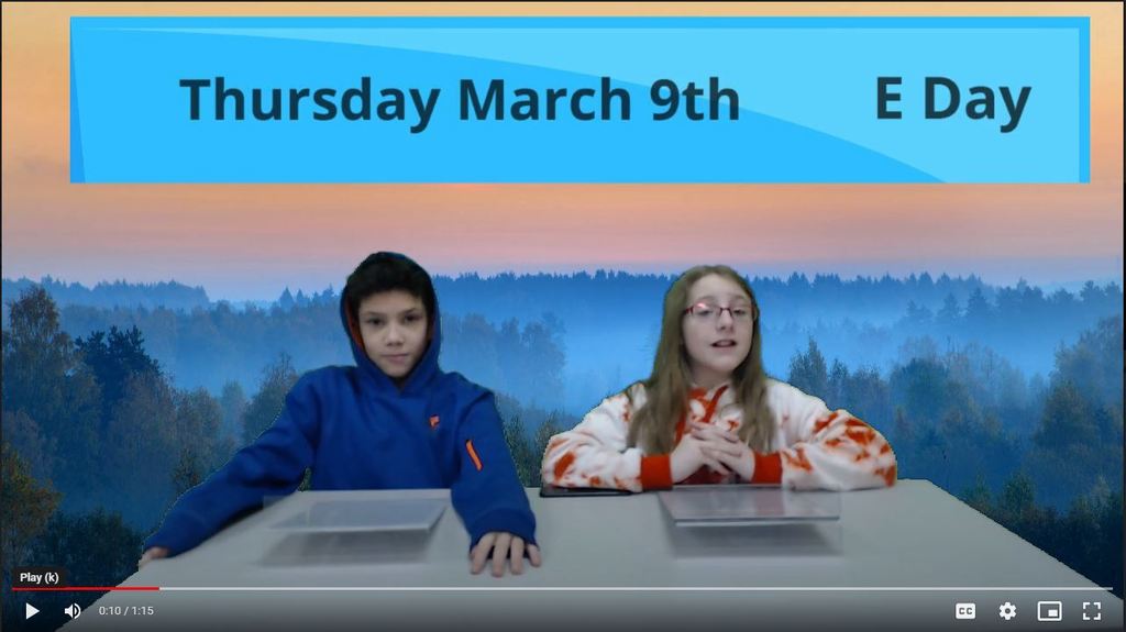 two students at news desk with forest green screen on background