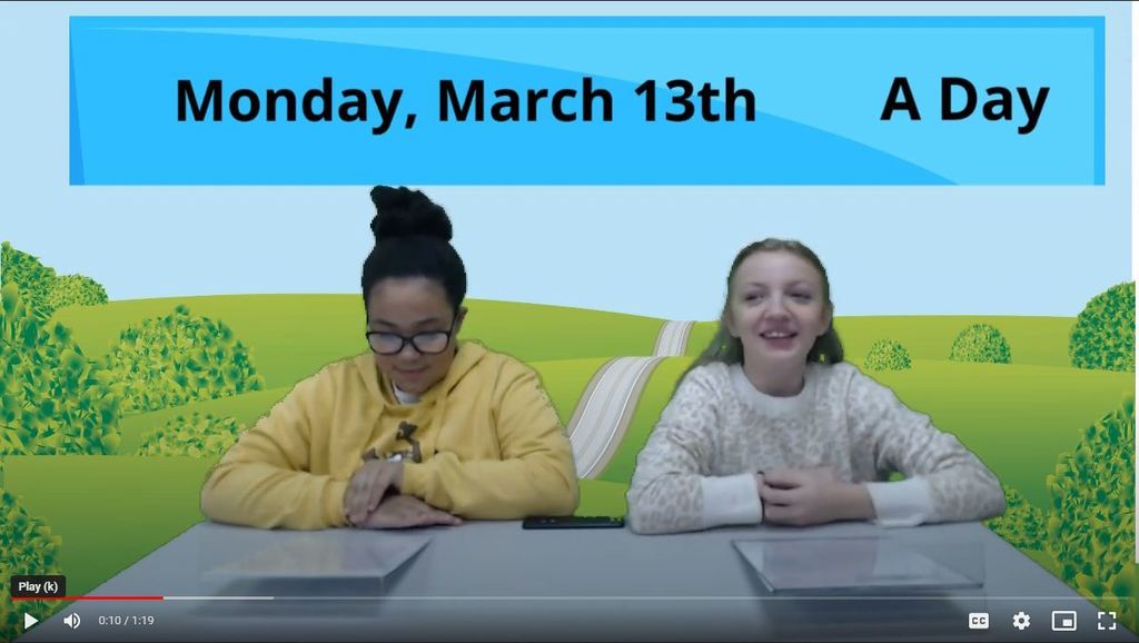 two students at news desk with rolling hills graphic on green screen